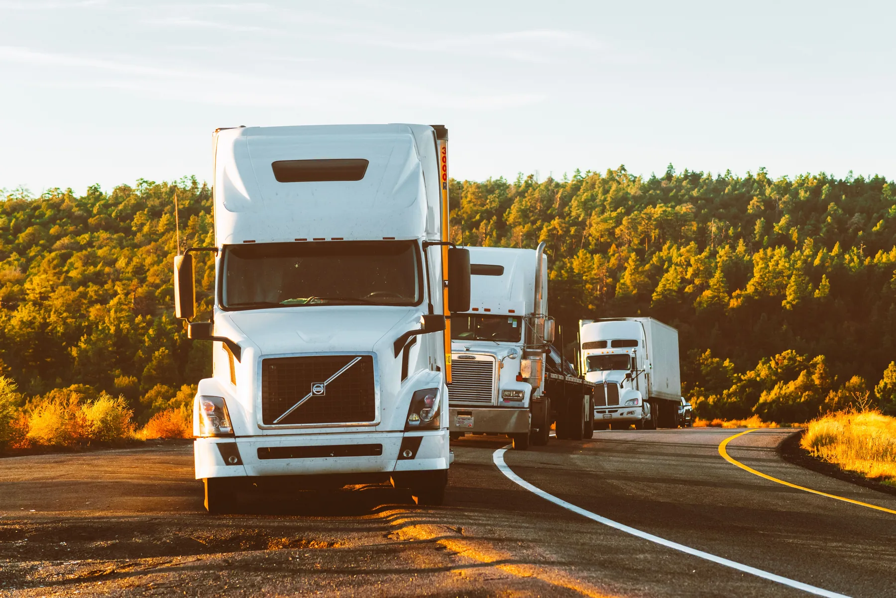 Commercial semi trucks traveling on a highway in the Pacific Northwest